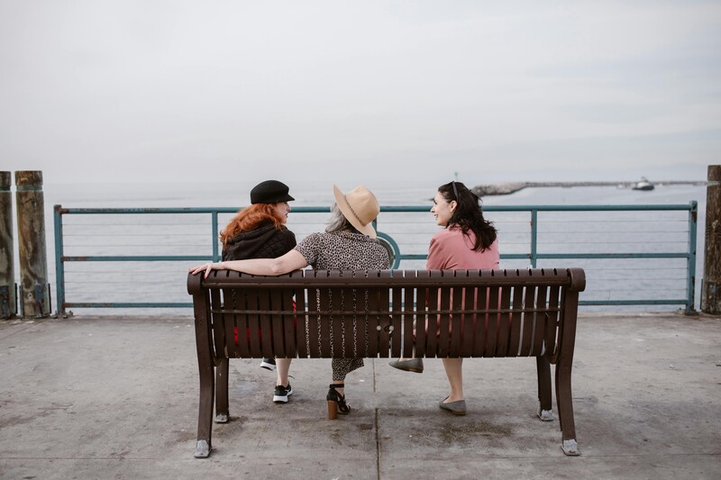 mensen zitten op een bank aan zee