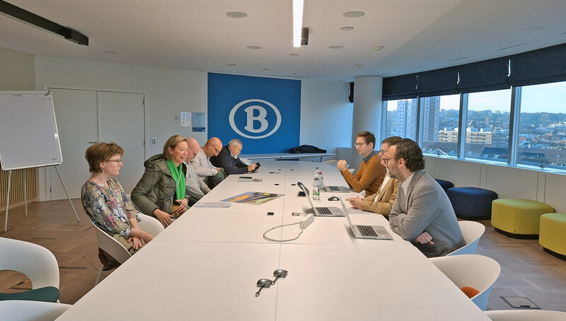 In een vergaderruimte aan een lange witte tafel gaat een ACV-delegatie in gesprek met drie afgevaardigden van NMBS.