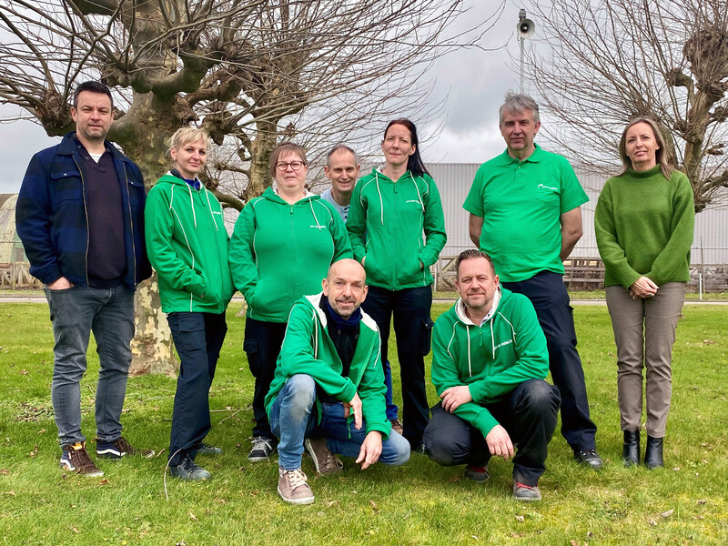 Negen ACV-militanten van Premium Sound Solutions in Dendermonde poseren voor het bedrijf.