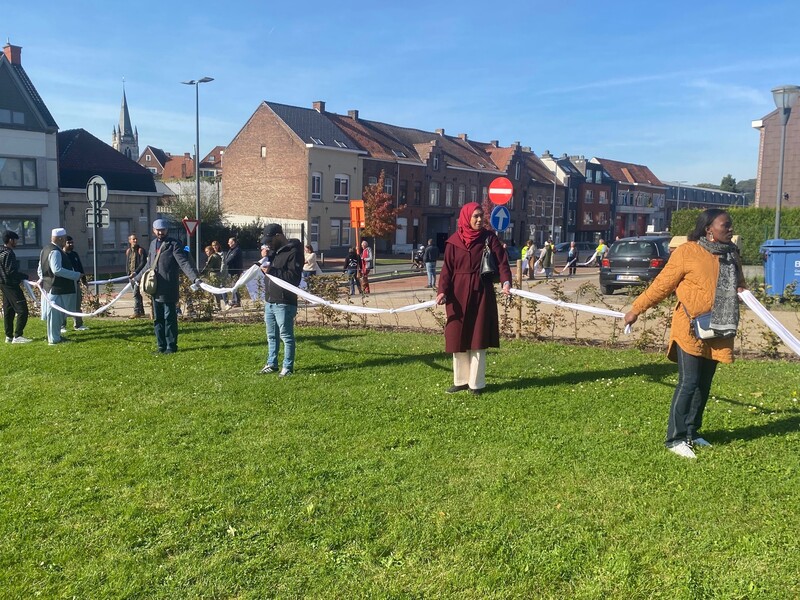 Mensen vormen een ketting met witte lakens in het centrum van Ronse.