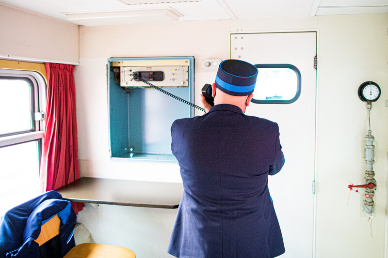Treinbegeleider praat door de intercom van de trein, op de rug gezien