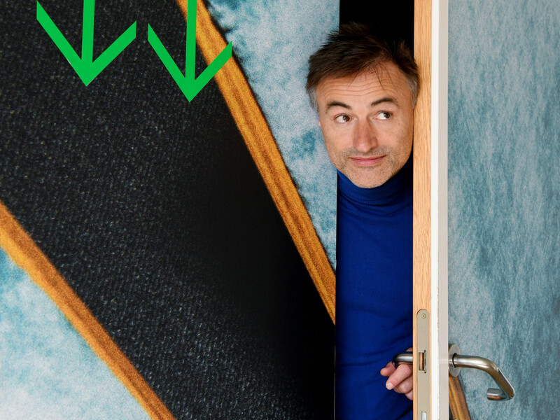 Acteur Dimitri Leue kijkt met zijn hoofd door een deurkier 