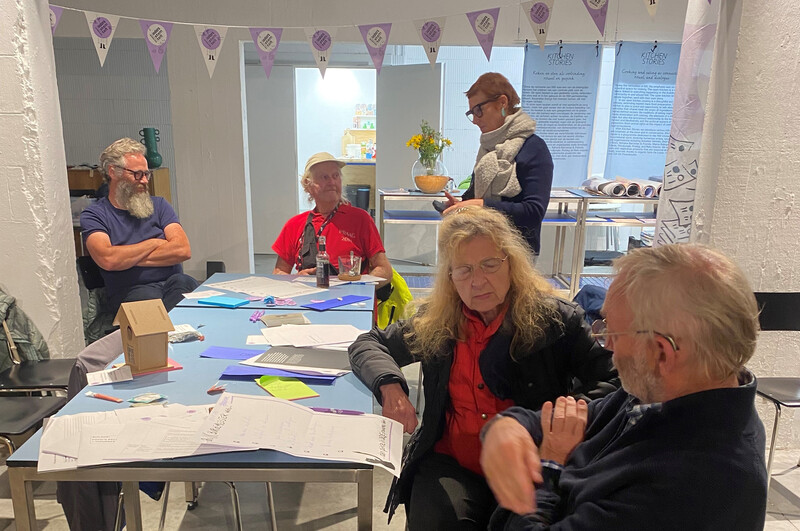 Enkele mensen zitten aan tafel en discussiëren over de afschaffing van de opkomstplicht.