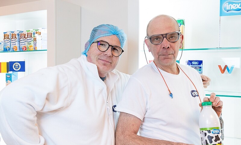Christophe en Guy poseren in werktenue met een fles Inex-melk.