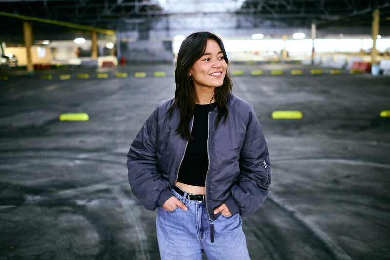 Camille Vanuxem op overdekte parking met handen in haar broekzakken