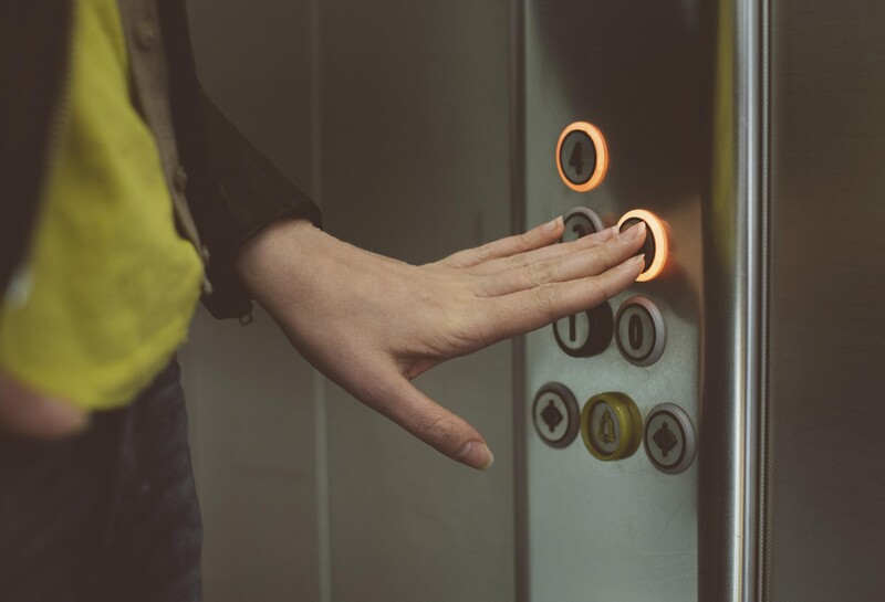 Vrouw in lift drukt op knop