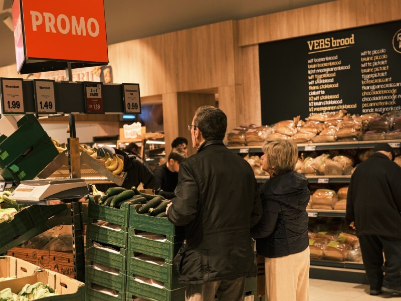 Ouder koppel in supermarkt Lidl kijkt naar promotie in groentenafdeling