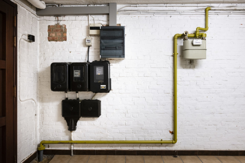 Elektriciteits- en gasmeter tegen een witte keldermuur