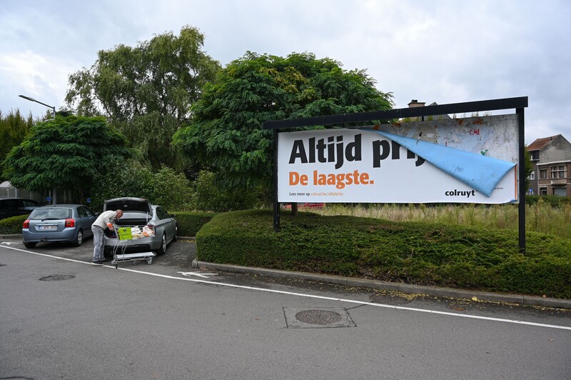 Afgebladerd reclamebord van Colruyt, met de slogan 'altijd prijs'