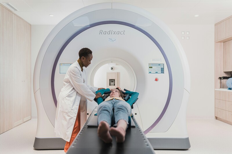 patiënt op tafel van MRI-scan met radioloog erbij