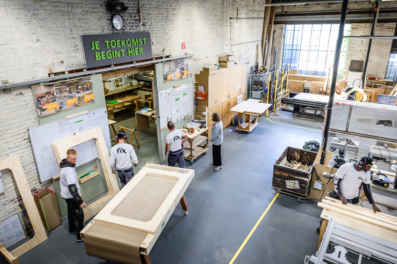 jongemannen aan het werk in Akoestiekfabriek