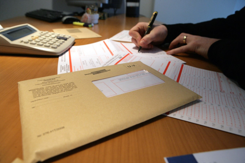 Persoon is belastingbrief aan het invullen.