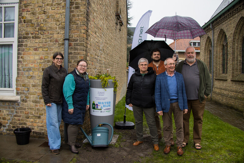 Een eerste regenton geplaatst door beweging.net in Diksmuide. Nele De Wachter, Gaëlle Beeusaert en Anuschka Dildick naast Diksmuidse vrijwilligers Robin Doom, Martin Obin en Koen Doom