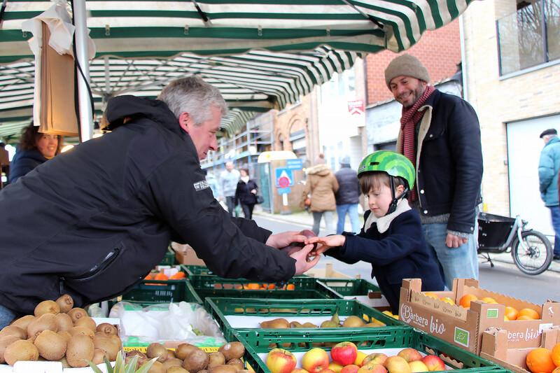vader en zoon kopen verse groenten op de markt