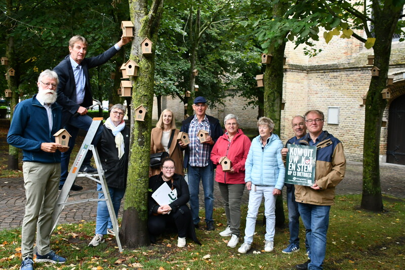 Vrijwilligers van beweging.net afdeling Nieuwpoort hangen vogelhuisjes op in de bomen