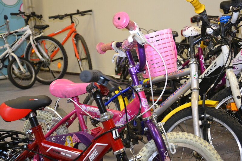 Enkele kinderfietsen van verschillend formaat staat op een rij opgesteld.