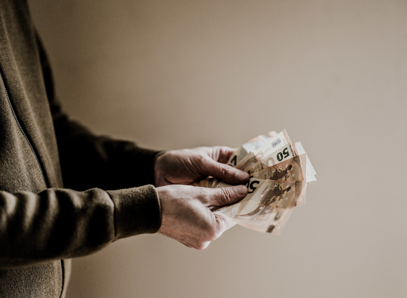 een man heeft briefjes van 50 euro vast