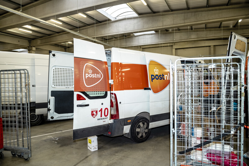 Openstaande bestelwagen van PostNL in het magazijn
