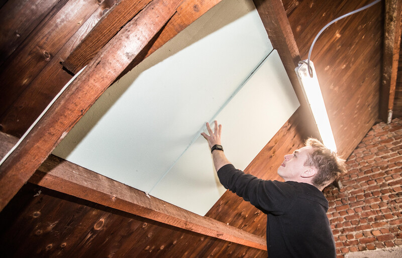 jongeman voert onder het dak kleine werken uit