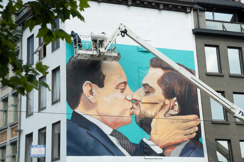 Muurschildering op Bolivarplaats in Antwerpen van Bart De Wever en Georges-Louis Bouchez die elkaar kussen