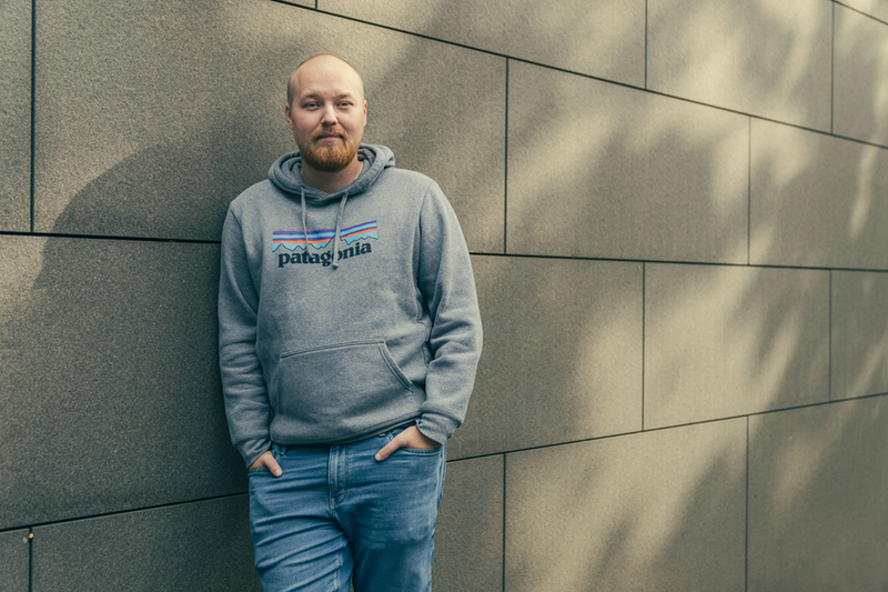 Mathias Mortelmans poseert tegen bakstenen muur