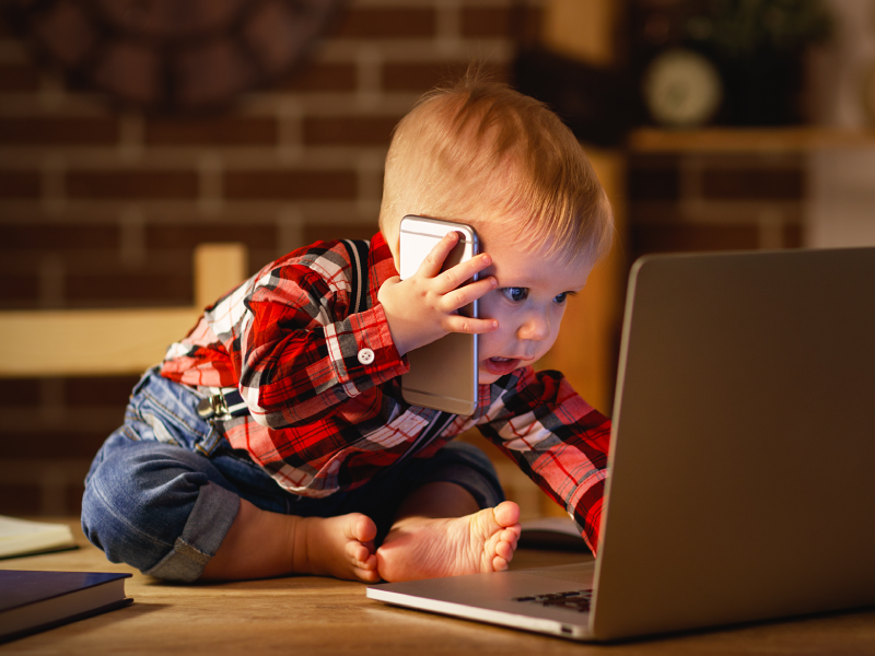 Baby die werkt en belt voor een laptop