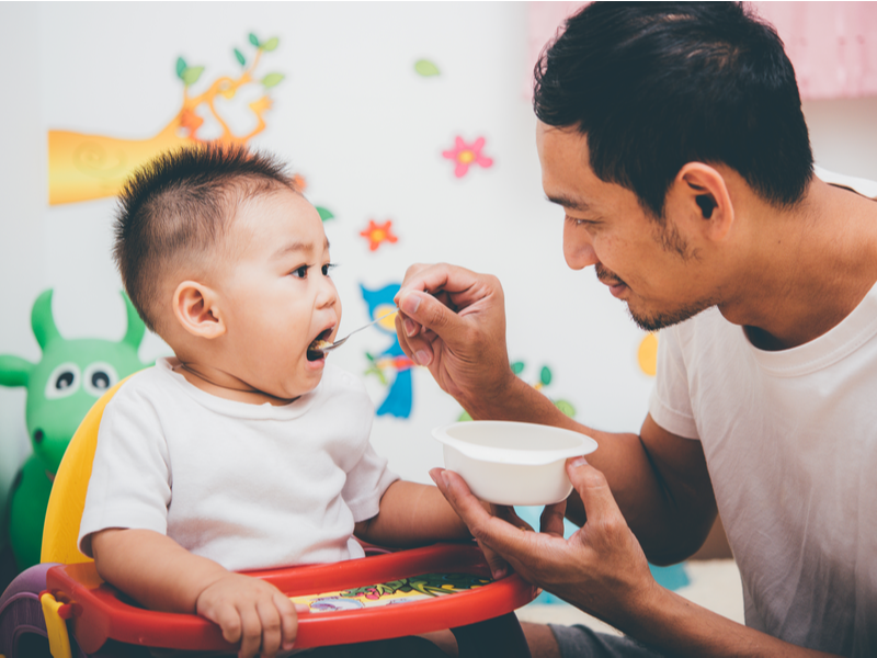 Papa geeft papje aan peuter