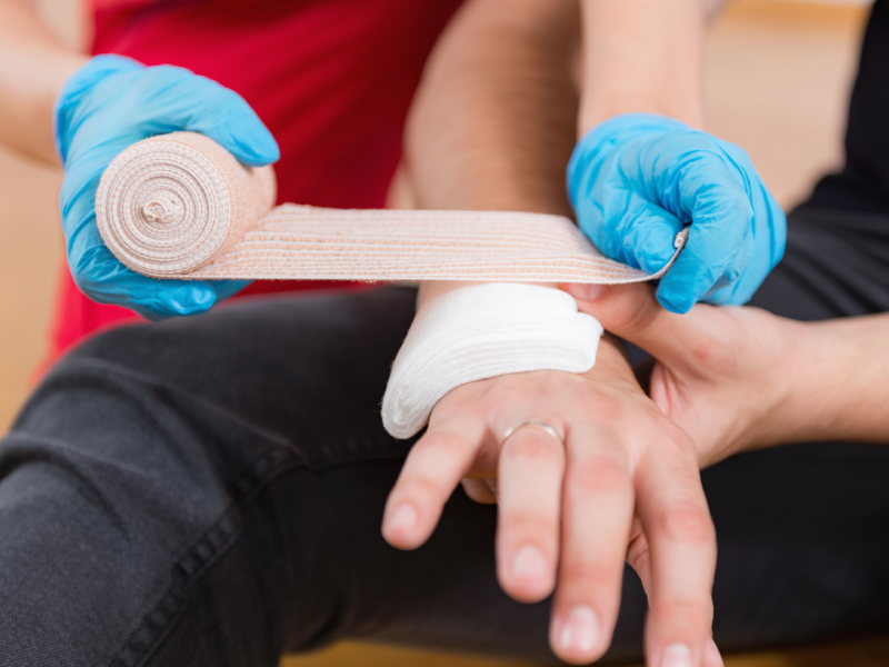 Verpleger helpt met handwonde