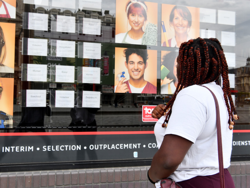 Vrouw leest vacatures aan raam interimkantoor
