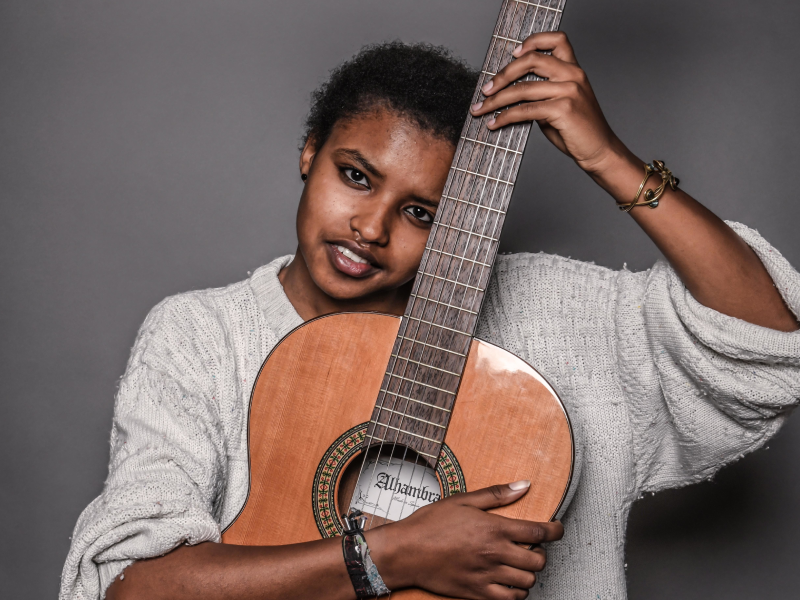 Meskerem Mees met een gitaar in haar handen