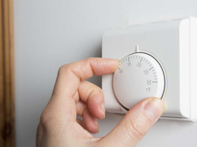 Vrouw die draait aan temperatuurregelaar