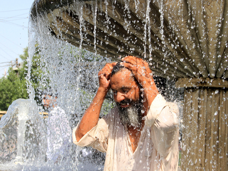 Pakistaanse man gebruikt fontein om zichzelf af te koelen tijdens een hittegolf