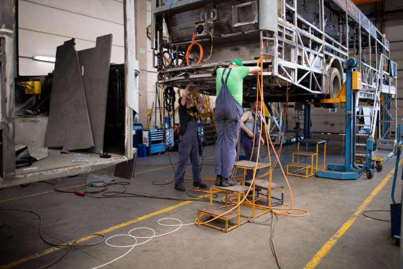 Arbeiders werken aan bus in fabriek van Van Hool in Lier