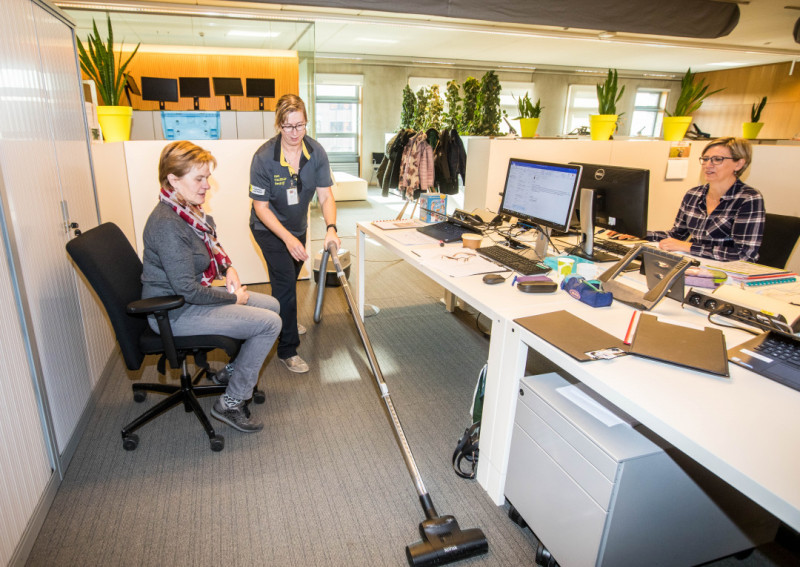Kuisvrouw aan het werk op kantoor waar twee vrouwen aan de slag zijn