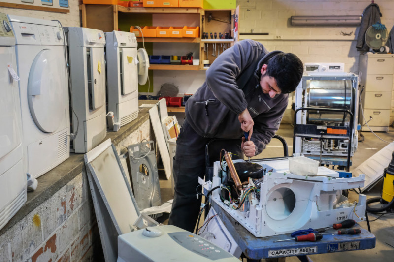 Man repareert wasmachines in kringloopwinkel voor doorverkoop