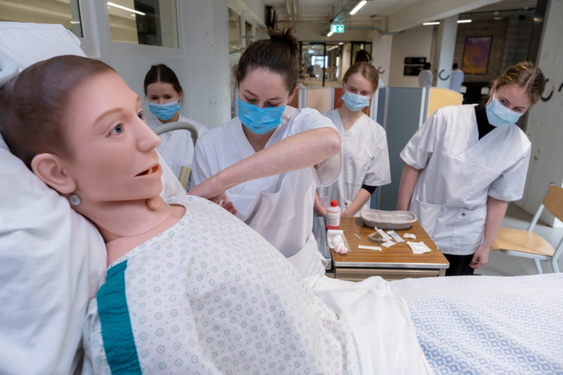 Studenten-verplegers aan het oefenen om spuiten te zetten op een pop