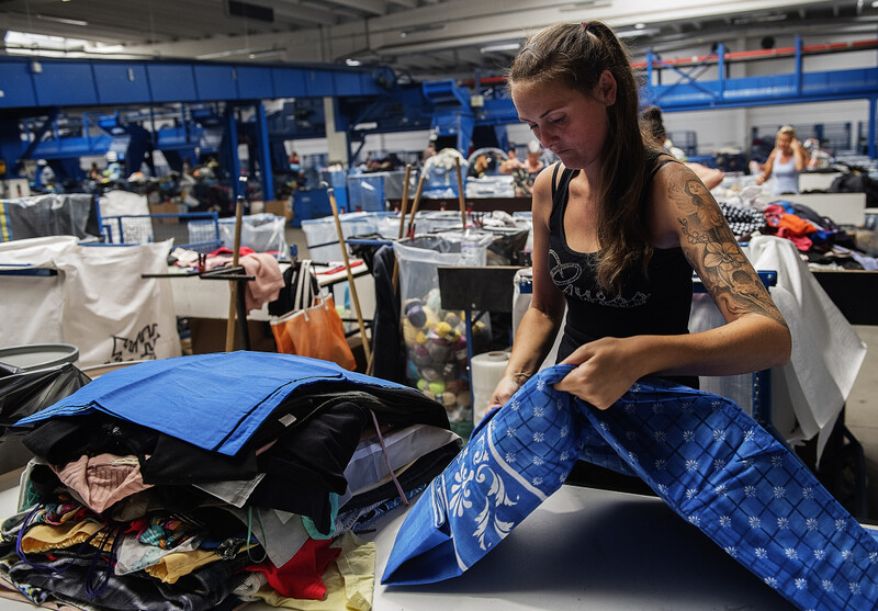 Naaister aan het werk in een textielbedrijf dat textiel recycleert