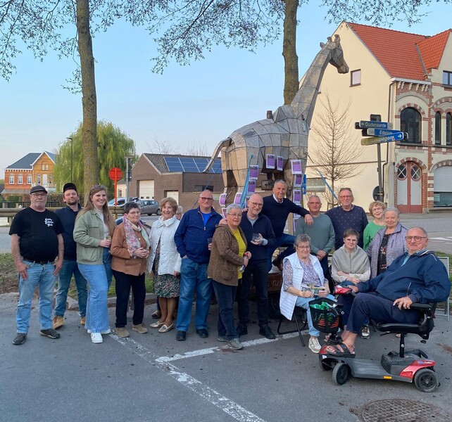 Zestien buurtbewoners uit de Bergstraat in Oudenaarde poseren voor een levensgrote houten giraf.