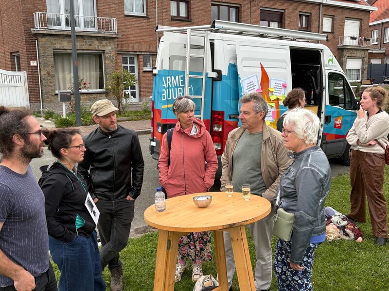 Zes mensen staan aan een hoge houten tafeltje en bespreken er de PFAS-problematiek in hun buurt.