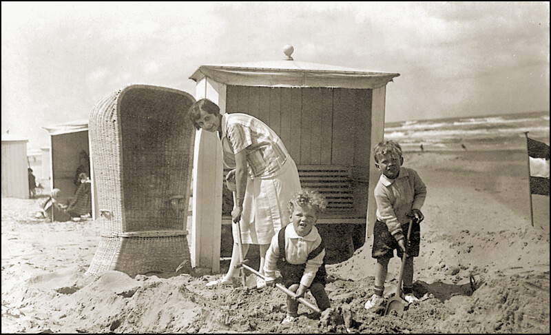 Oude vakantiefoto van mama met twee kindjes die aan het spelen zijn op het strand