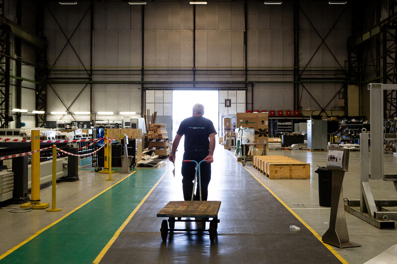 Man trekt lege kar door fabriekshal