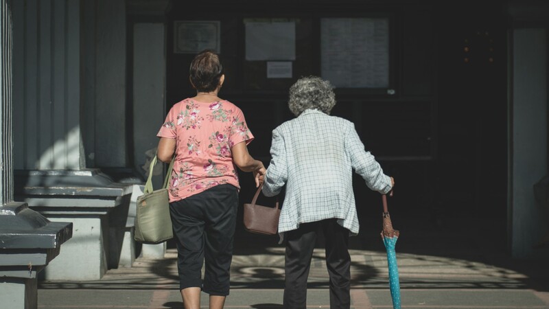 Twee vrouwen, de jongere vrouw onderteunt de oudere vrouw