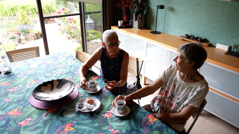 Twee gepensioneerde dames aan tafel drinken koffie
