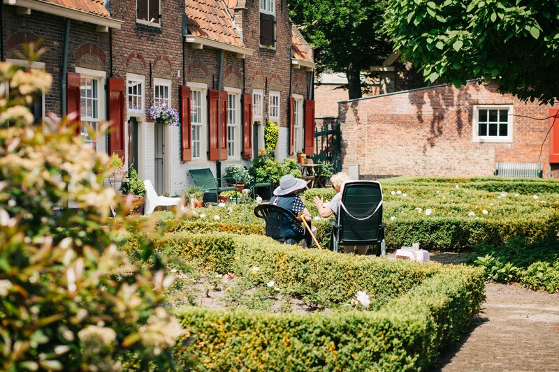Twee vrouwen zitten in een tuin