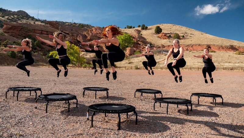 Vrouwen in sportkledij springen op kleine trampolines