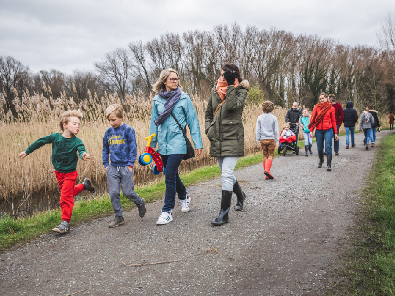 Gezinnen met kinderen wandelen op een koude lentedag