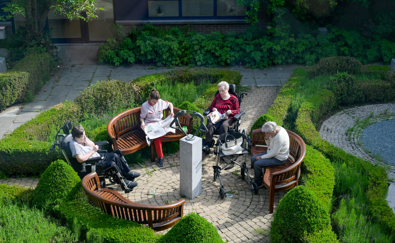 Bejaarden zitten in de tuin van een woonzorgcentrum