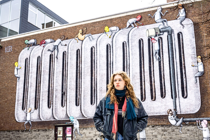 Getuige Roos Mertens voor een graffiti-muur van kunstenaar Bisser over de klimaatopwarming