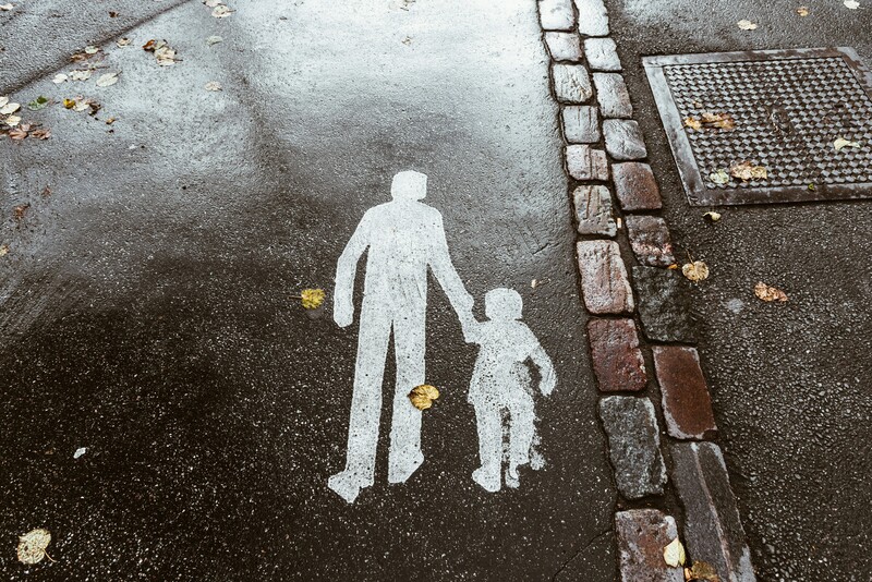 waarschuwingsmarkering op het wegdek van een ouder met kind aan de hand