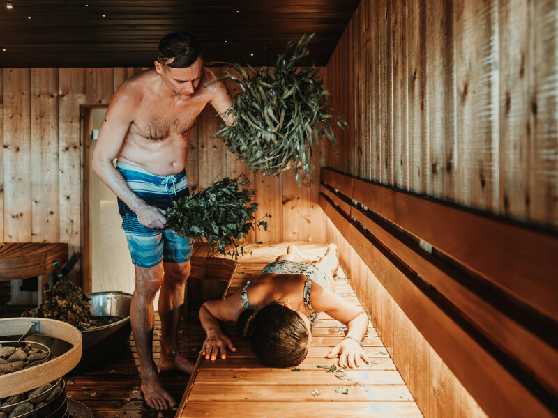 man slaat vrouw in sauna met berkentakken